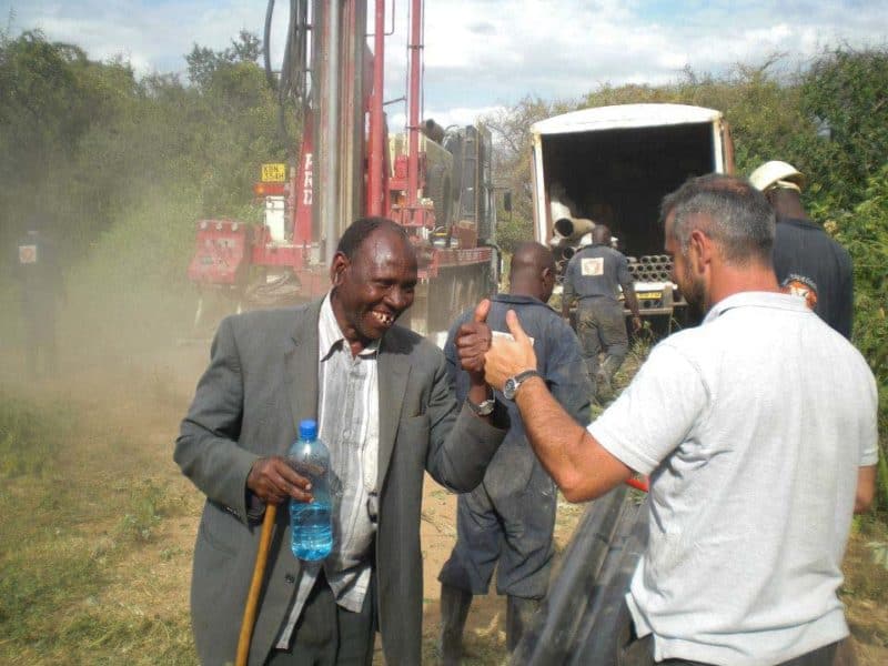 Two men with smiling faces and thumbs up are happy about finding water at a depth of 170m.